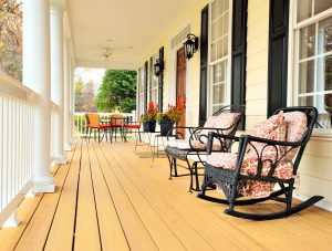 6249216 - low angle view of a large front porch with furniture and potted plants. vertical format.