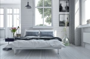 38436632 - double divan bed in a light spacious upmarket modern bedroom with large windows and artwork on the walls in grey and white decor