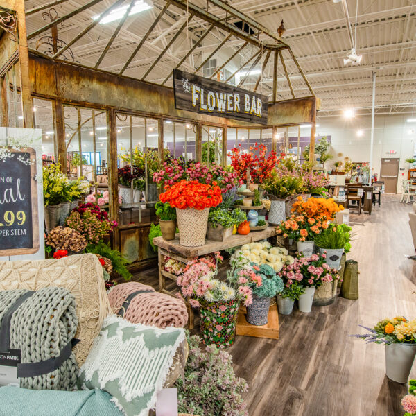 outdoor accents display with fake flowers in Home Zone store room