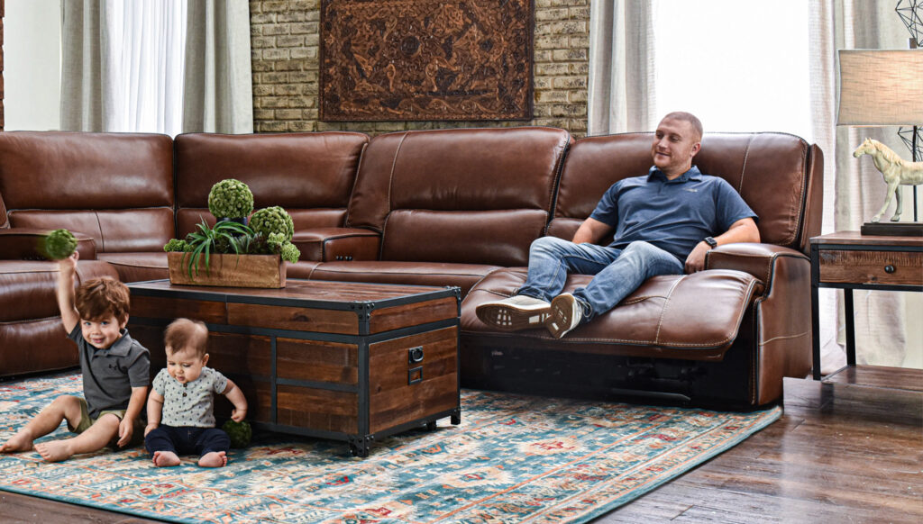 man sitting in brown sectional recliner